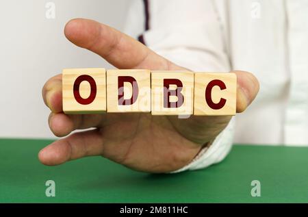 In the man's hand are cubes with the inscription - ODBC. Stock Photo