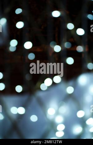 Background, bokeh blurred light from garlands burning with white light Stock Photo