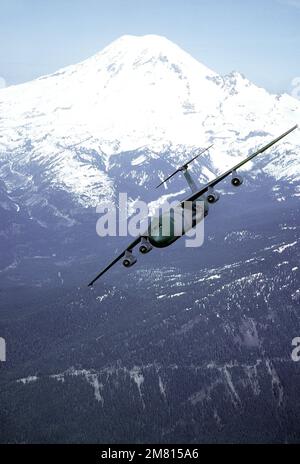 Air to air side view of Air Mobility Command's 62nd Airlift Wing, McChord  AFB, Washington C-130 Hercules and C-141 Starlifter flying with Mt. Ranier  in the background. Exact Date Shot Unknown - NARA & DVIDS Public Domain  Archive Public Domain Search