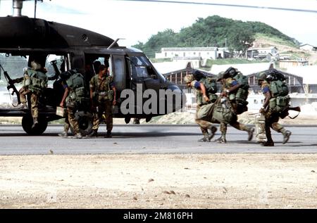 Members of the Eastern Caribbean Defense Force board a UH-60 Black Hawk helicopter during Operation URGENT FURY. Subject Operation/Series: URGENT FURY Country: Grenada (GRD) Stock Photo
