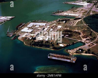 An aerial view of various ships moored in the harbor, with a floating dry dock in the foreground. Base: Apra Harbor State: Guam (GU) Country: Northern Mariana Islands (MNP) Stock Photo