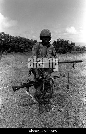 A Marine displays a seized Soviet RPG-2 rocket launcher and Bren light machine gun, after arriving with Battalion Landing Team A during Operation Urgent Fury. They were deployed from Grenada when informed that members of the Peoples Revolutionary Army were here on the island. Subject Operation/Series: URGENT FURY Base: Carriacou Island Country: Grenada (GRD) Stock Photo