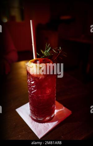 cranberry fizz cocktail in a pub with rosemary and lemon Stock Photo