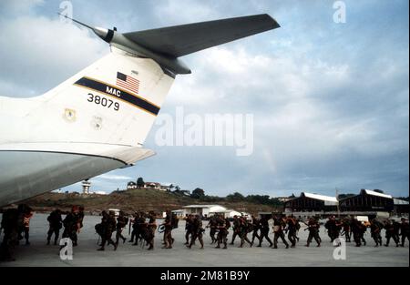 US military personnel board a C-141B Starlifter aircraft at Point ...