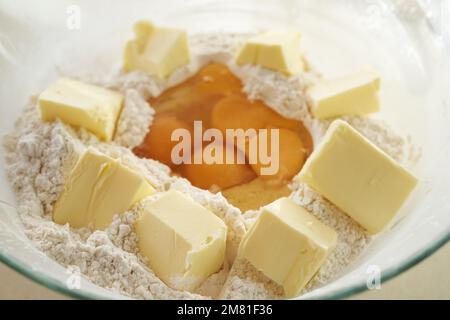 Pieces of butter and wheat flour in a glass bowl - preparation for baking cookies Stock Photo