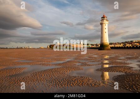 New Brighton, UK: Perch Rock Lighthouse reflected in water pools at low tide. An iconic landmark on the Wirral peninsula. Stock Photo