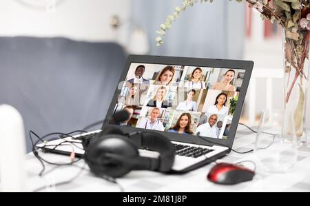 Laptop and headset on table at home, videoconference Stock Photo