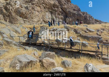 BISOTUN, IRAN - JULY 13, 2019: Visitors walking around archeological area in Bisotun, Iran Stock Photo