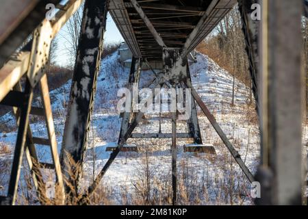 Steel beams under a railway bridge on a sunny winter afternoon in Northern Ontario. Stock Photo