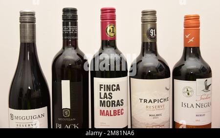 A row of five bottles of red wine with a bottle of Malbec Finca Las Moras wine, produced in Argentina, in the centre, against a white background. Stock Photo