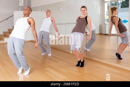 Adult dancers practicing synchronous choreography in studio Stock Photo