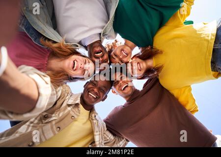 Internacional Erasmus students looking at camera cheerfully embracing each other. Stock Photo