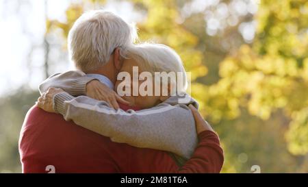 Married grey-haired couple hugging outdoor. High quality photo Stock Photo
