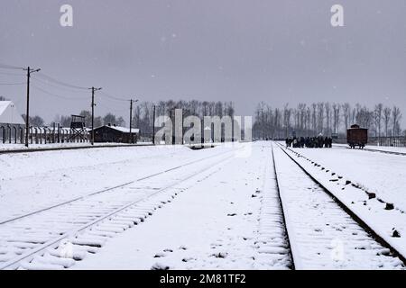 Railway lines leading to the entrance to Auschwitz Birkenau Concentration camp, in winter snow, Auschwitz Holocaust Memorial, Krakow Poland Europe Stock Photo