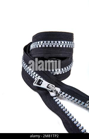 Jacket Winter Coat Black Tape Heavy Duty Zippers Large Molded Plastic Zippers. Close-up of zipper slider on a white surface. Sewing production, materi Stock Photo