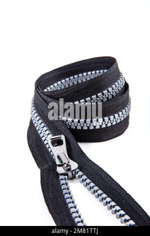 Jacket Winter Coat Black Tape Heavy Duty Zippers Large Molded Plastic Zippers. Close-up of zipper slider on a white surface. Sewing production, materi Stock Photo