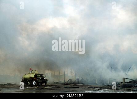 A firetruck from the 3rd Civil Engineering fire department is manned by American and Filipino firefighters attempting to extinguish the fire engulfing the U.S. Facilities 3rd Supply Squadron covered storage area 11A. Damages were estimated to be $3 million. Base: Clark Air Base State: Luzon Country: Philippines (PHL) Stock Photo