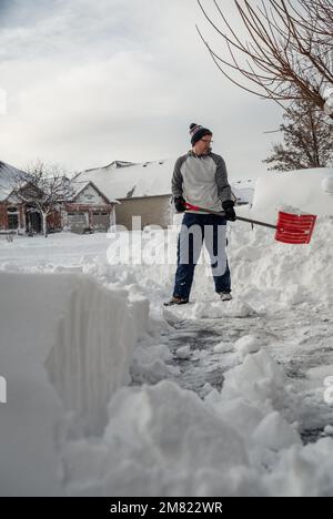 Man shoveling snow off of his driveway after a winter storm. Stock Photo