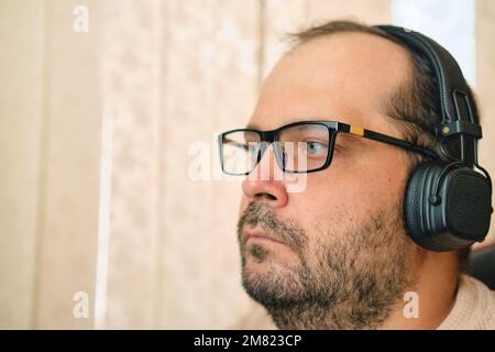 A European man in glasses and headphones closeup portrait Stock Photo