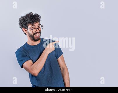 Friendly handsome man pointing two fingers to the side, Smiling handsome man pointing two fingers to the side. Concept of a young man pointing at a Stock Photo