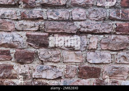 A brown brick wall. Repeated background of the Stone Wall Stock Photo