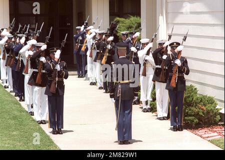 A joint services honor guard, bringing their rifles to order arms, lines the walkway at the main chapel during an arrival ceremony for the Unknown Serviceman of the Vietnam Era. The Unknown will lie in repose in the chapel until the morning of May 25th, when he will be placed aboard an aircraft for a flight to Washington, District of Columbia. Base: Travis Air Force Base State: California (CA) Country: United States Of America (USA) Stock Photo