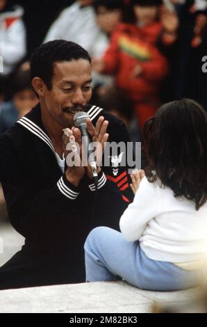 Musician 1ST Class (MU1) Manny Rivera-Cepeda of the UNITAS XXV Band sings to a little girl during a concert in Valparaiso. UNITAS XXV is an operation involving the US Navy and navies from South American countries. Subject Operation/Series: UNITAS XXV Country: Chile (CHL) Stock Photo