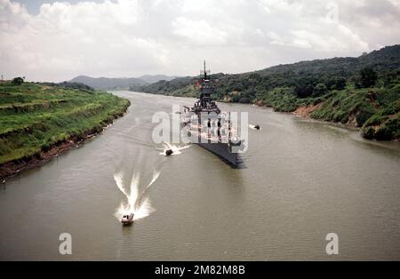 Elevated starboard bow view of the battleship USS IOWA (BB 61) passing through the Gaillard Cut during its transit of the canal. The IOWA is escorted by Navy PBR Mark-II river patrol boats. State: Canal Zone Country: Panama (PAN) Stock Photo