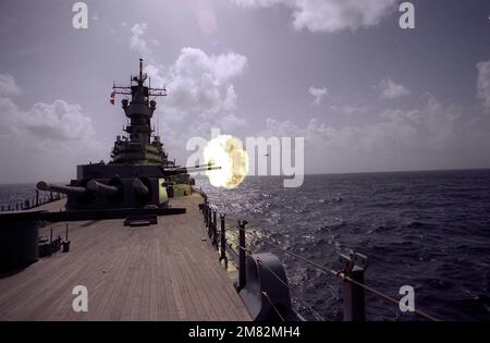 The battleship USS IOWA (BB-61) fires a round from its No. 2 Mark 7 16-inch/50-caliber gun turret. Country: Unknown Stock Photo