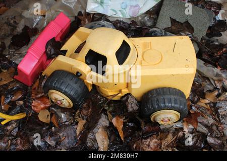 Yellow plastic bulldozer on wet ground Stock Photo