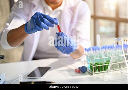 Professional male scientist or chemist working in the forensic science laboratory, testing new serum sample. cropped shot Stock Photo