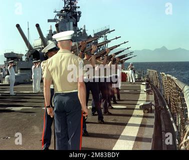 A Marine honor guard aboard the battleship USS IOWA (BB-61) fires a 21-gun salute during a burial at sea. Country: Unknown Stock Photo