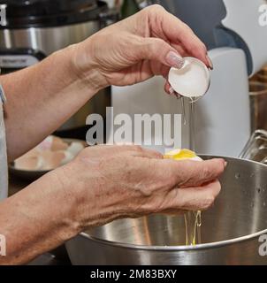 Chef separates the yolk from the protein to make the pie. Stock Photo