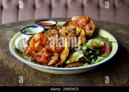 Patacón breakfast. The patacón, tostón, tachino or frito is a meal based on fried flattened pieces of green plantain Stock Photo