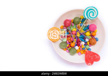 Lollipops and candies in bowl isolated on white background Stock Photo