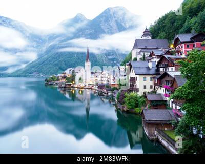 A breathtaking postcard view of buildings and Hallstatter See in Hallstatt, Austria on foggy day Stock Photo