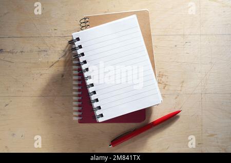 Stack of notebooks and pen on old wooden background, top view Stock Photo