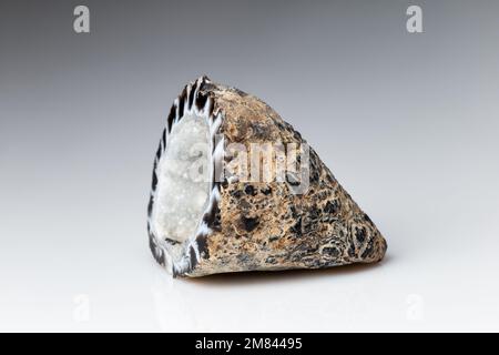 Agate Geode with Hyaline Quartz Crystals on Grey Background. A Cross Section of Pure, clear or colorless quartz Formed within Volcanic Rock Stock Photo