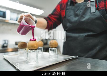 decorating chocolate balls with pink cream in the bakery, dessert concept. High quality photo Stock Photo