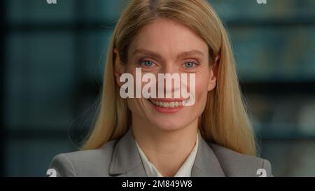 Beautiful smiling toothy dental smile happy female face Caucasian mature middle-aged adult woman looking at camera posing alone in office millennial Stock Photo