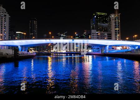 panoramic view of footbridge with tourists leading to numerous skyscrapers with hotels and residential buildings on the Persian Gulf coast in Dubai at Stock Photo