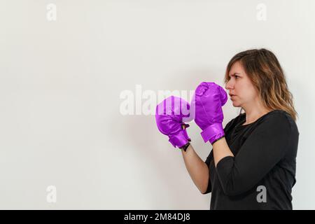 woman with purple boxing gloves ready for a fight Stock Photo
