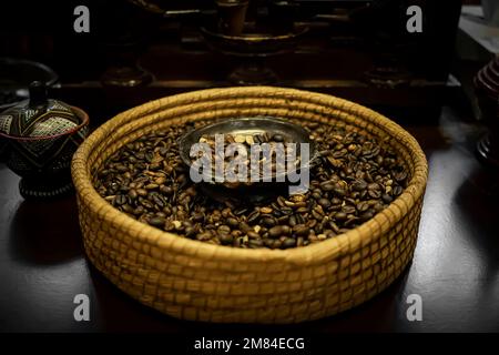 Roasted coffee beans in bowl close up on black background, clipping path Stock Photo