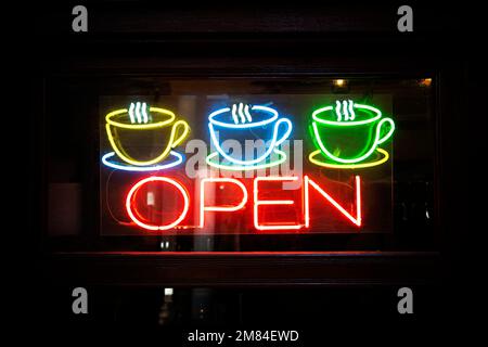 Neon open sign with coffee cup on glass door. an open cafe. Stock Photo
