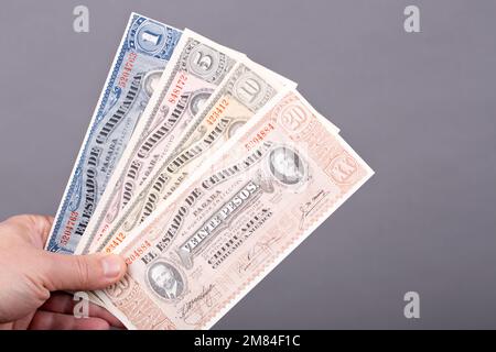 Old Mexican money - Pesos in the hand on a gray background Stock Photo
