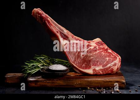 Raw Tomahawk beef steak and spices. Ready for grilling Stock Photo