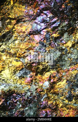 Microscope image of colorful copper ore. This is copper sulphide called Chalcopyrite, It has the chemical formula (CuFeS2). Stock Photo