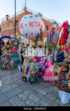 A wedding party on the street posing with dancers, a farolero and monos de calenda in Oaxaca, Mexico. Stock Photo