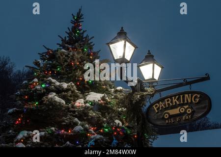 Lighted Christmas tree with street lamps and a vintage parking for 1 cent sign on an early morning in downtown Taylors Falls, Minnesota USA. Stock Photo