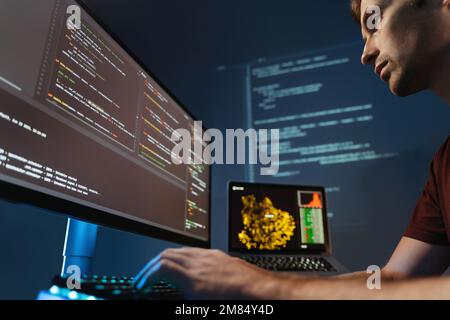 Closeup of concentrated programmer working on pc programming, writing code for application or website design at home office for software development company Stock Photo